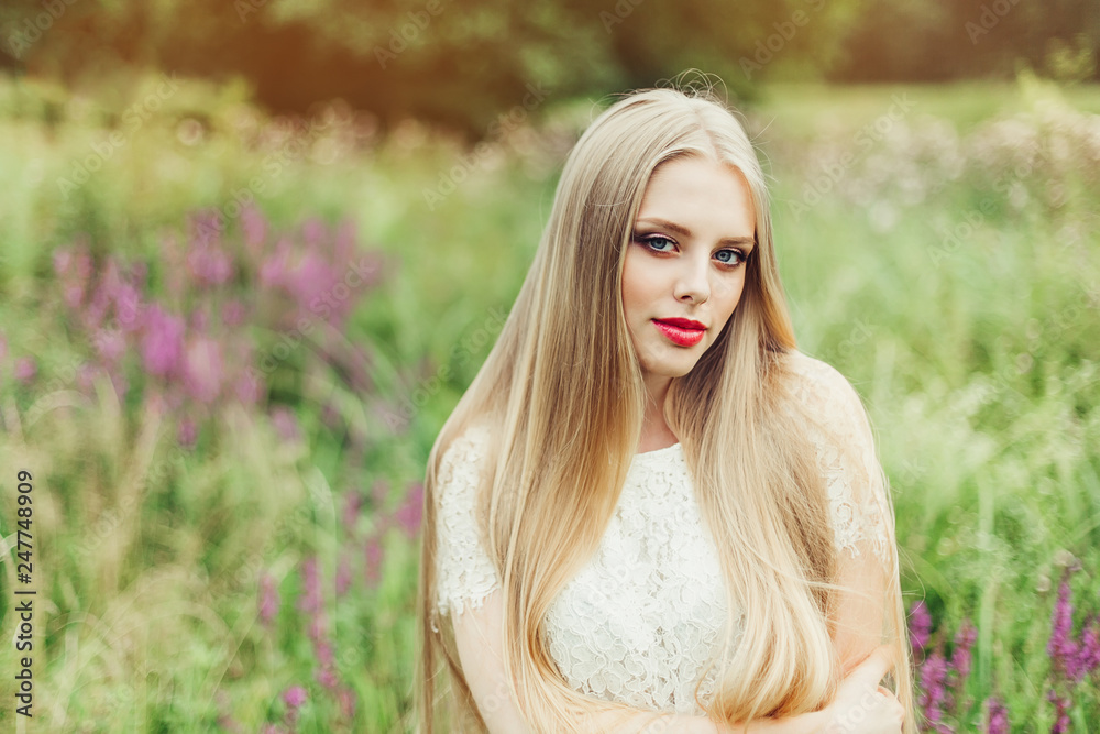 Naklejka premium Close up natural portrait of young happy cute cheerful caucasian beautiful girl witn long natural blondie hair walking in park in summer evening
