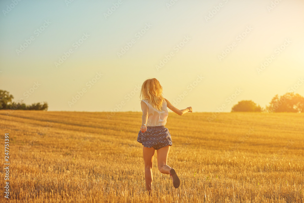 Cute young woman jumping in a wheat field. Cute young woman jumping in a wheat field.