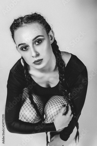 Сharismatic young girl in sexy swimfit with pigtails posing in studio photo