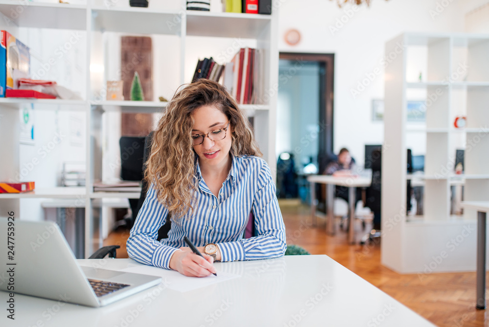 Smiling administrative assistant or manager taking notes. Smiling administrative assistant or manager taking notes.