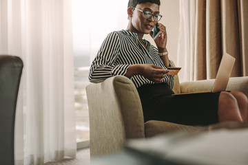 Female CEO doing online payments with credit card and laptop at