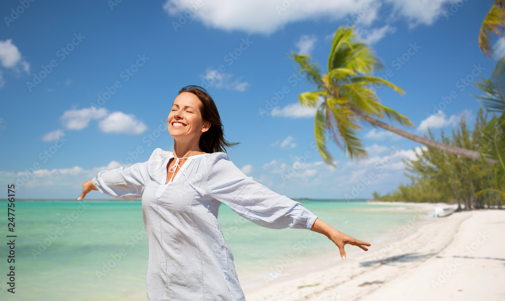 travel, tourism and summer vacation concept - happy smiling woman over tropical beach background in french polynesia