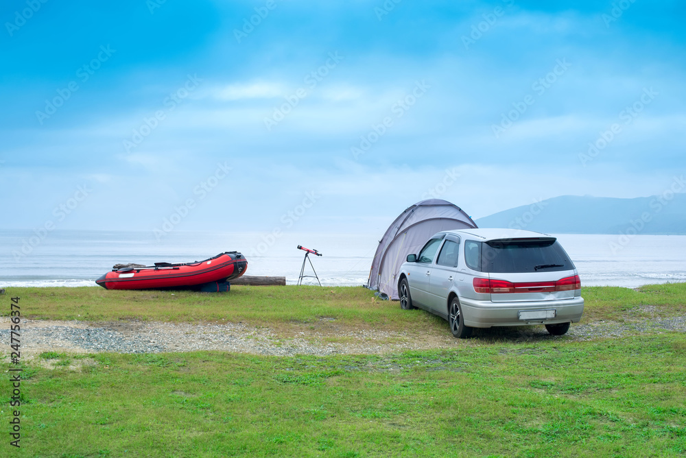 Seascape summer travel machine tent rubber boat Coastline horizon sky with clouds