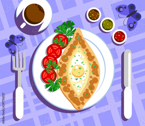 Khachapuri - tortilla with cheese, on a plate surrounded by greens and slices of tomatoes