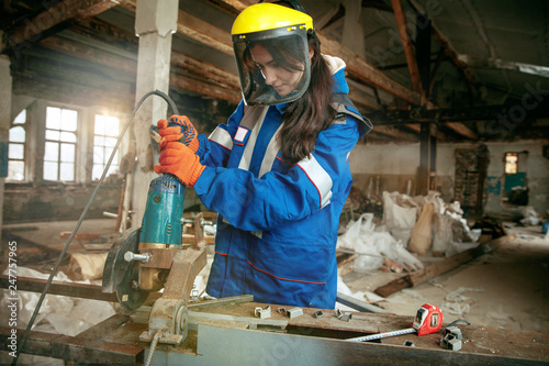 Destroying gender stereotypes. Woman wearing helmet using different male work tools. Gender equality. Girl working at flat remodeling. Building, repair and renovation. woman in the male profession