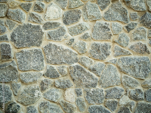 Close up view on grey stone wall surface. Detail of rock wall. Abstract background. Stone wall texture, closeup. An old grey blocks pattern