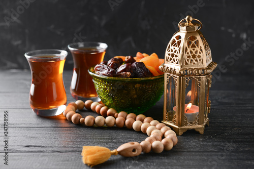 Quadro su tela Muslim lamp, dried fruits, tea and tasbih on wooden table