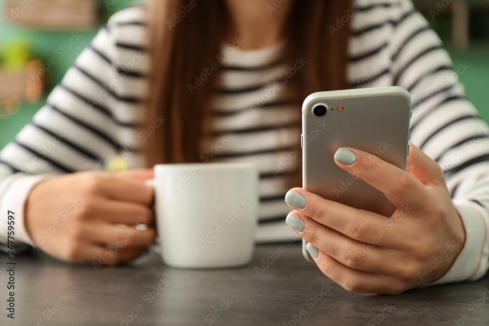Young woman with mobile phone using wifi in cafe, closeup Young woman with mobile phone using wifi in cafe, closeup