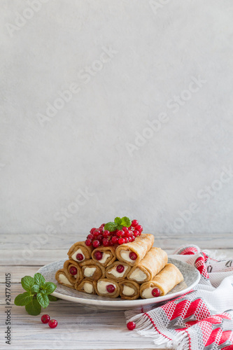 Pancake rolls with ricotta and mascarpone with red currants. photo