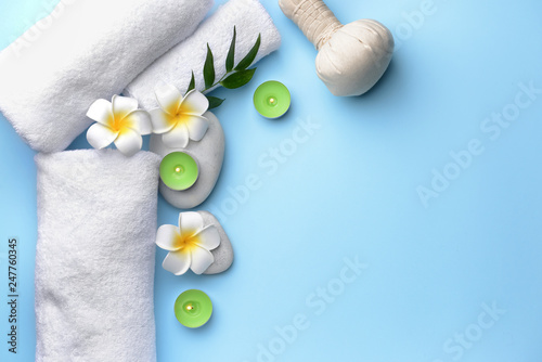 Spa composition with herbal bag, candles and flowers on color background