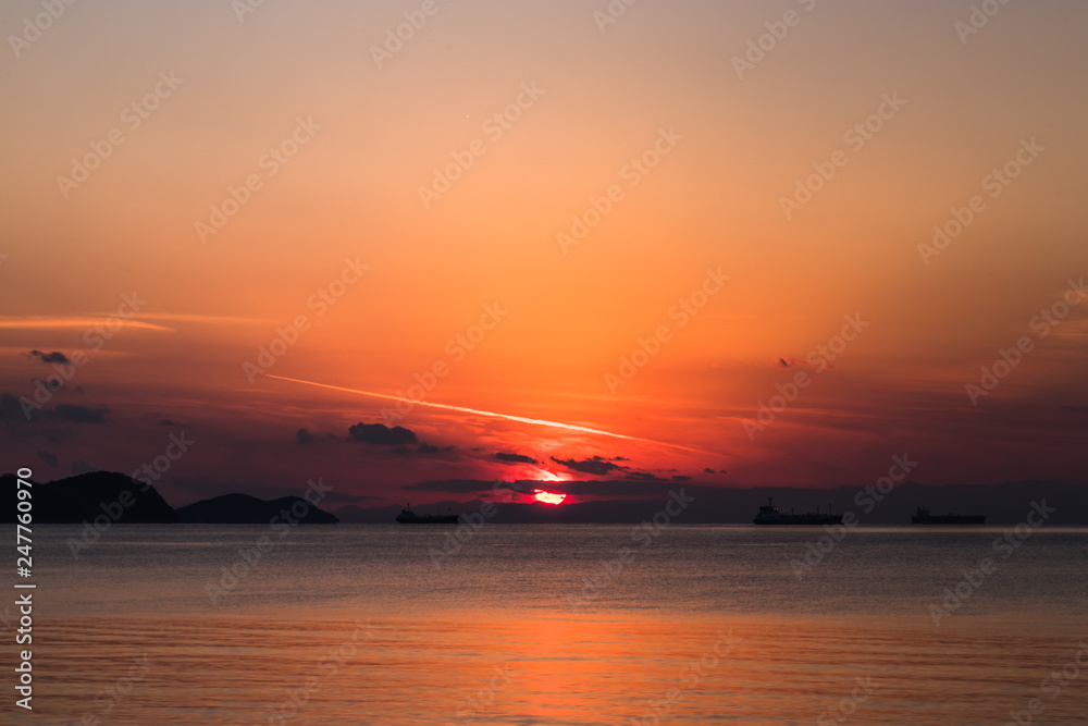 view of the orange sun falling over the sea and the beautiful sky