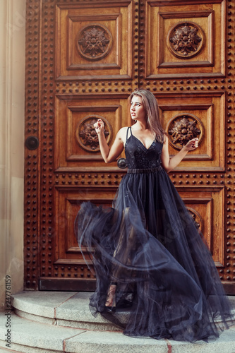 Fashionable close up street portrait of brunette beautiful girl walking in old town of Riga. Beauty, fashion concept