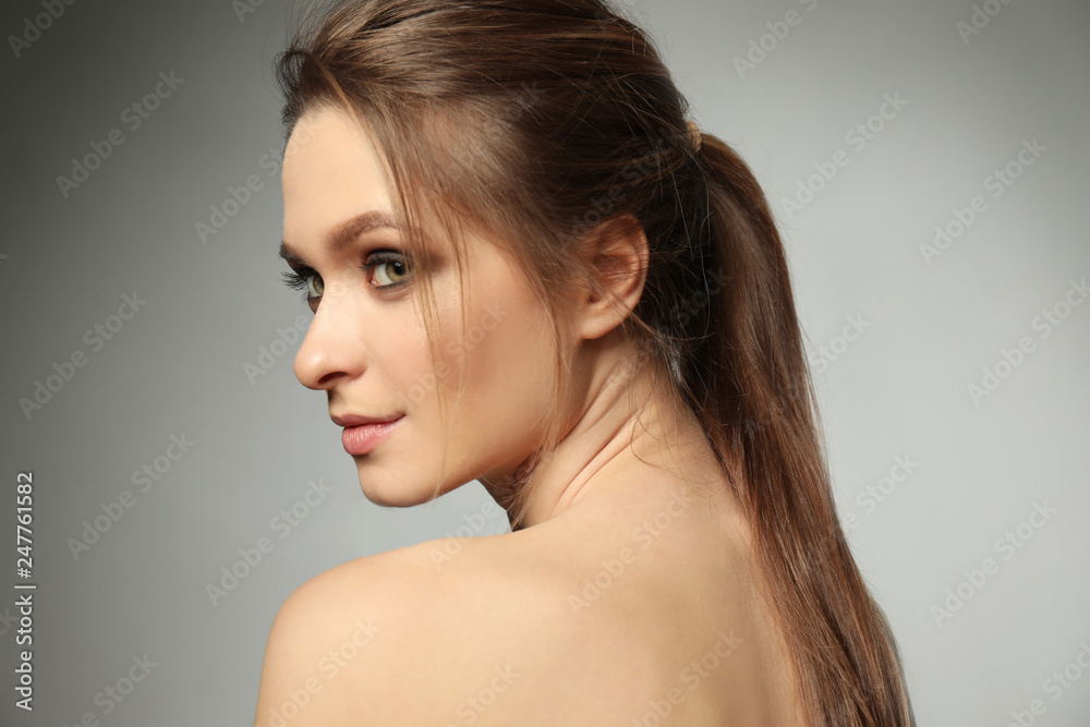 Portrait of beautiful young woman on grey background Portrait of beautiful young woman on grey background
