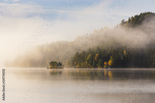 Foggy autumnal morning by the lake. Natural sunrise light. Trondheim area in Norway. photo