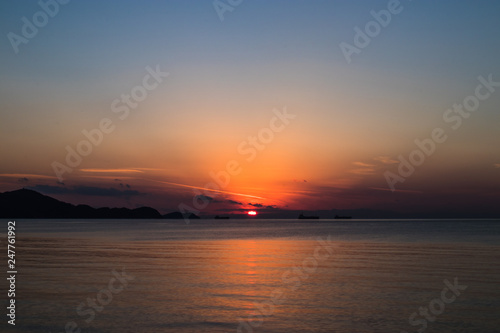 view of the orange sun falling over the sea and the beautiful sky © lapo
