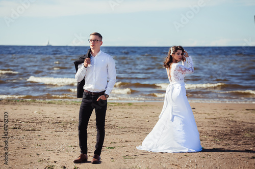 Happy young romantic cheerful loving wedding couple walking on the beach of sea. Happiness, couple, love concept