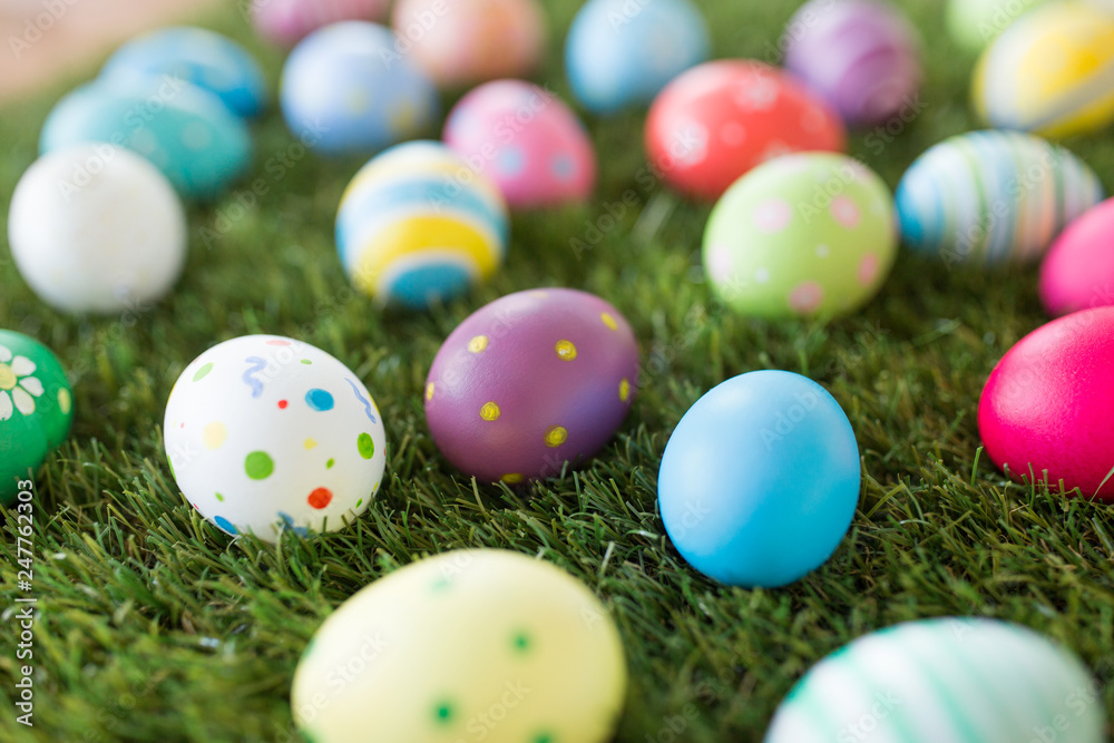 easter, holidays and tradition concept - colored eggs on artificial grass easter, holidays and tradition concept - colored eggs on artificial grass