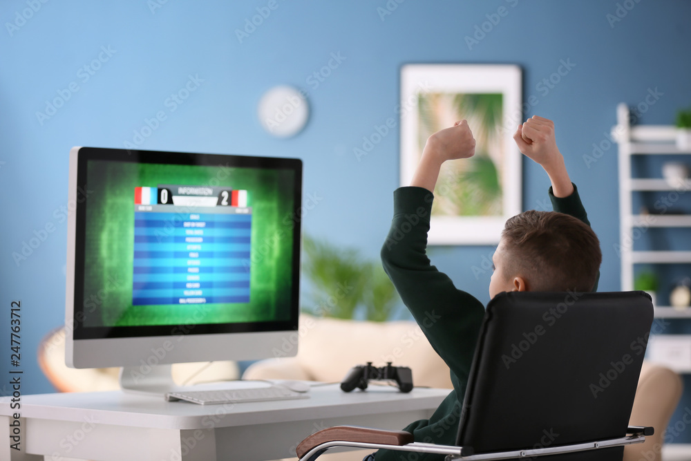 Emotional little boy playing computer game at home Emotional little boy playing computer game at home