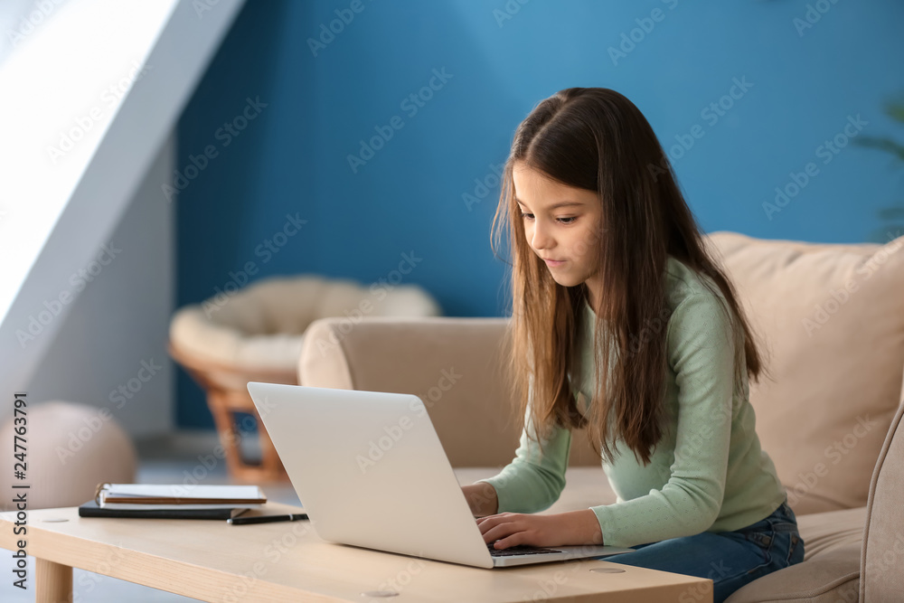 Cute little girl playing computer game at home Cute little girl playing computer game at home