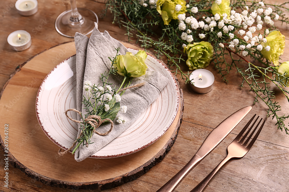 Beautiful festive table setting with floral decor on wooden background Beautiful festive table setting with floral decor on wooden background