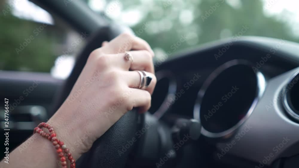 Close up of woman's hands on steering wheel driving convertible car Close up of woman's hands on steering wheel driving convertible car