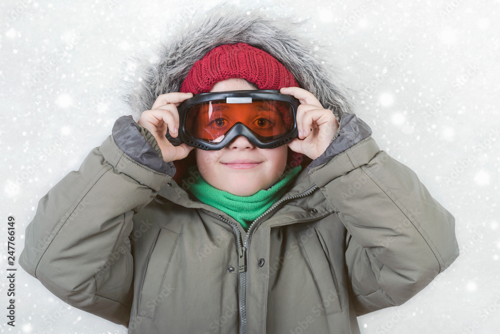 happy child in goggles in winter holidays