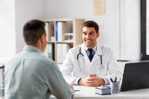 Tableau sur toile medicine, healthcare and people concept - smiling doctor talking to male patient
