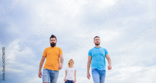 Keep it easy, simple and trendy. Young people in casual style on cloudy sky. Fashion people look casual in summer outfit. Pretty woman and men friends walking outdoor. Group of people in casual wear