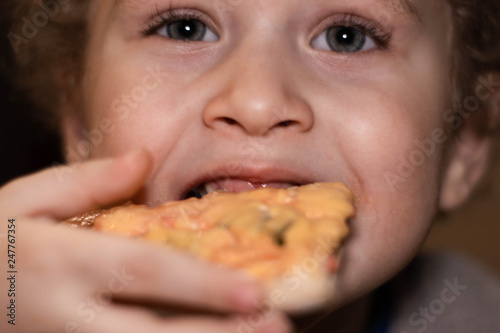 Little boy eats pizza. Portrait close-up