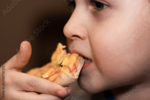Little boy eats pizza. Portrait close-up