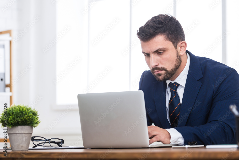 Full concentration. Businessman working on laptop in office Full concentration. Businessman working on laptop in office
