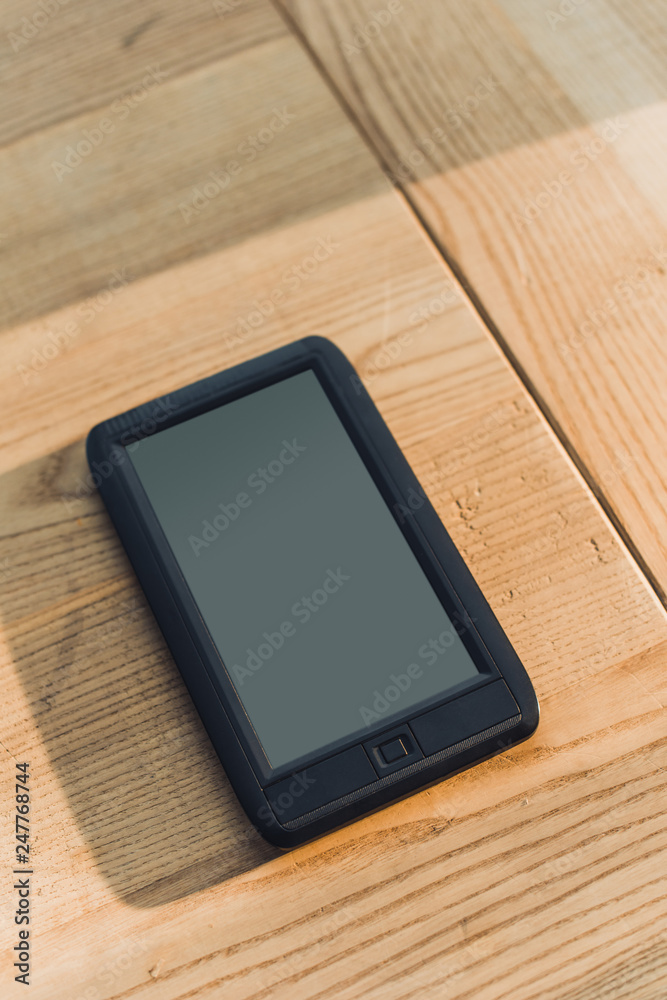 ebook with blank screen lying on wooden table ebook with blank screen lying on wooden table