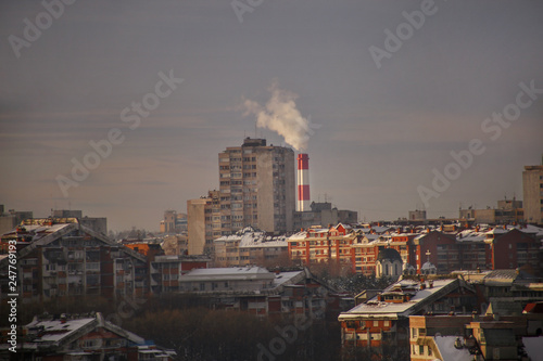 Smoking from industrial chimneys of heating plant emits smoke, smog at sunset in city, pollutants enter atmosphere. Environmental disaster. Harmful emissions, exhaust gases into air. Heating season. © zoranlino