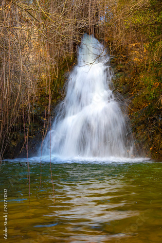 Front view of the waterfall among the autumn vegetation. Landscape