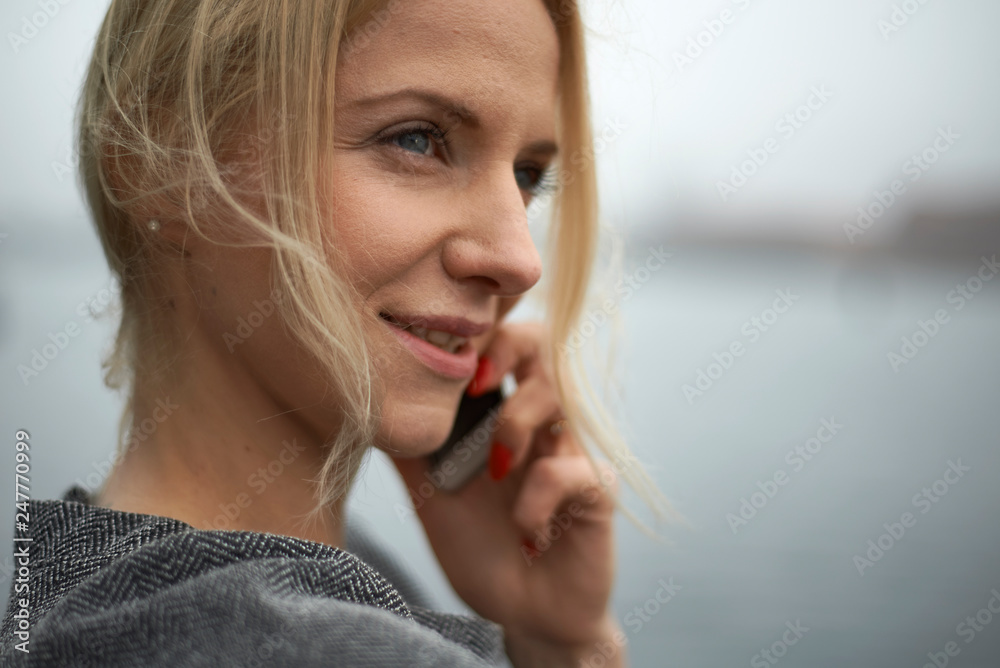 Fototapeta premium Beautiful young caucasian business woman using a mobile phone and laptop in various urban settings, shot in Copenhagen, Denmark