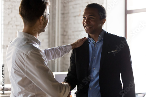 Caucasian boss handshake black employee greeting with success