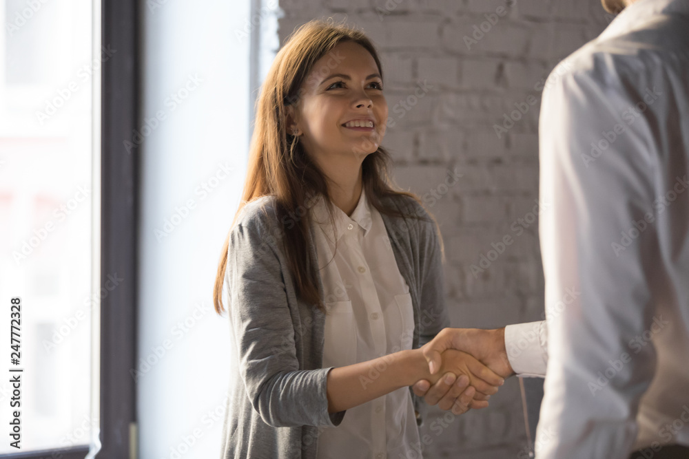 Businessman handshake excited female worker greeting with success