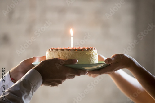 Close up of employee presenting cream pie with candle  photo