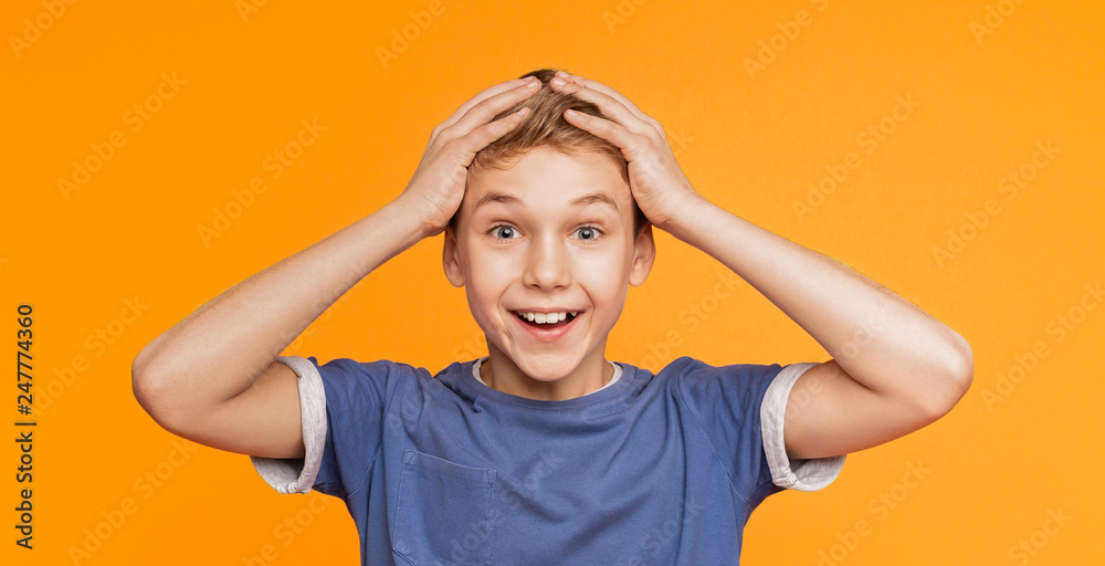 Surprised excited little boy holding hands on head Surprised excited little boy holding hands on head