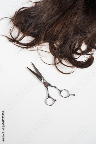 brunette long hair with scissors isolated on white background