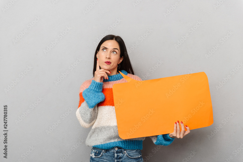 Portrait of adult woman 30s holding blank placard for text, isolated over gray background Portrait of adult woman 30s holding blank placard for text, isolated over gray background