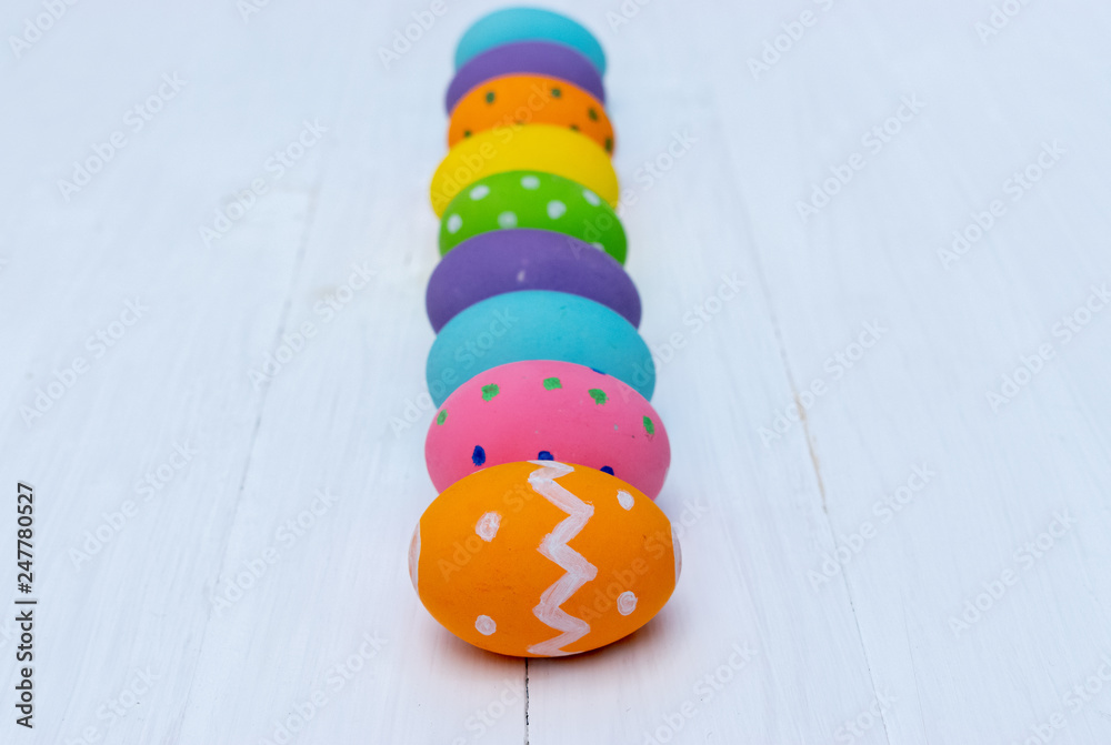 Happy Easter. Row colorful easter eggs on white wooden background.
