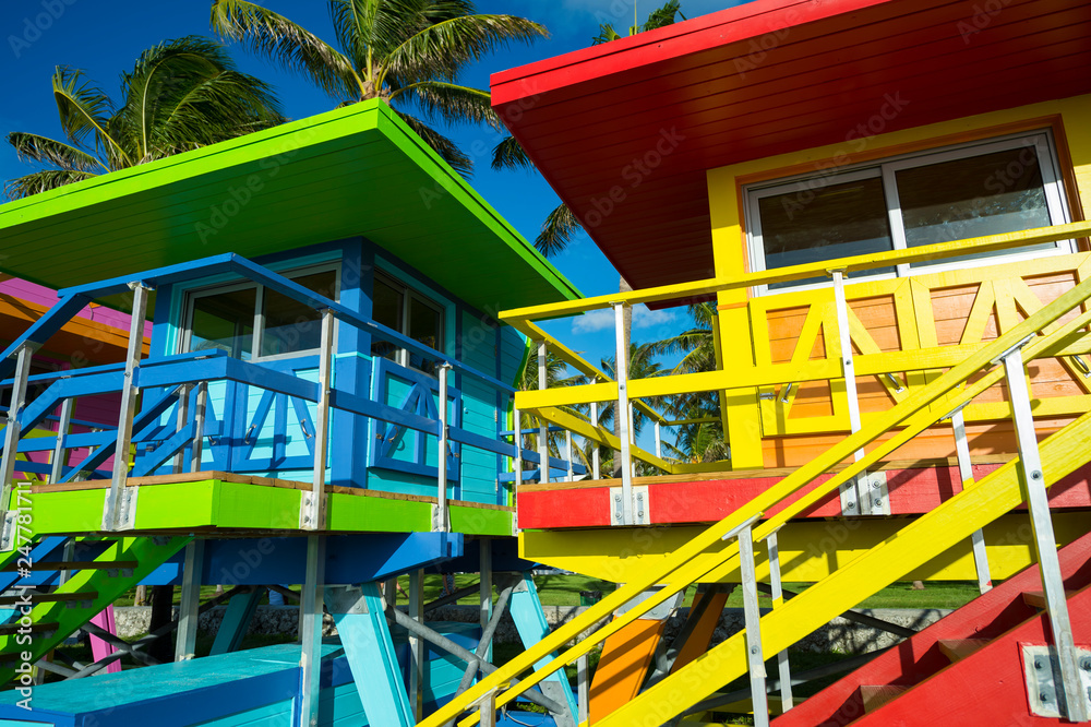 Scenic sunny view of brightly colored lifeguard towers lined up in a row on South Beach, Miami, Florida, USA
