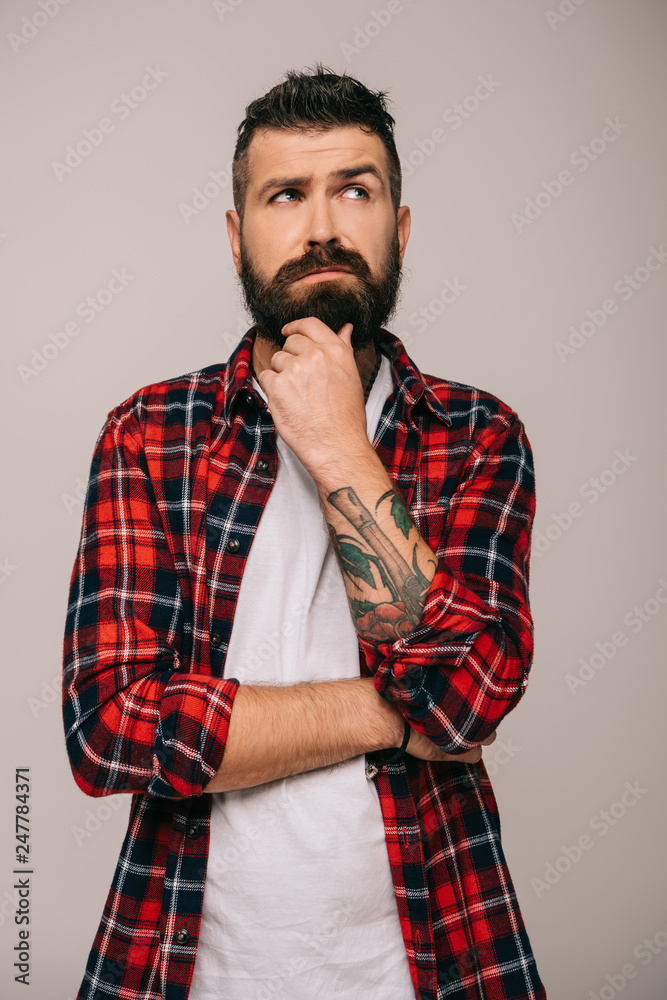 pensive bearded man in checkered shirt isolated on grey pensive bearded man in checkered shirt isolated on grey