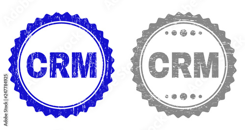 Grunge CRM stamp seals isolated on a white background. Rosette seals with grunge texture in blue and grey colors. Vector rubber stamp imitation of CRM title inside round rosette.