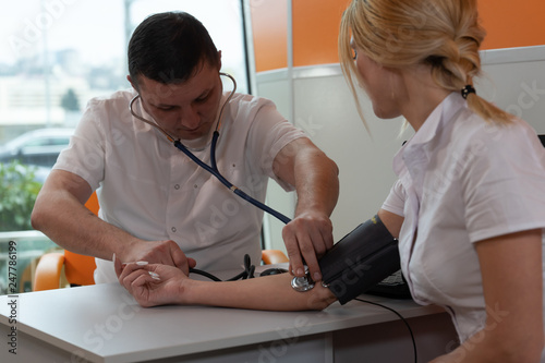 A doctor measuring blood pressure with sphygmomanometer