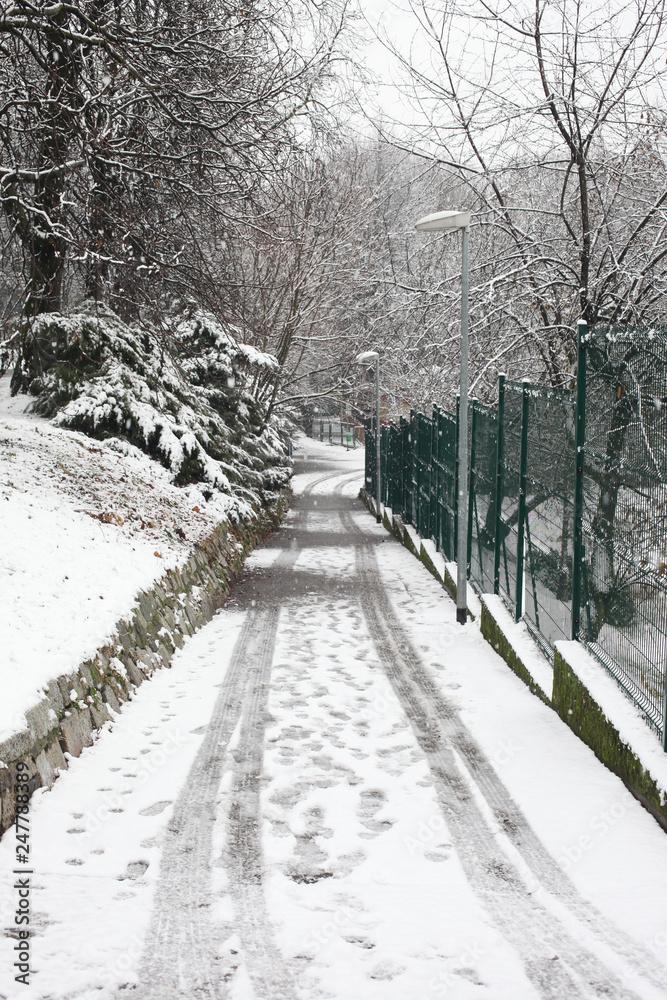 Naklejka premium covered snow alleyway in a city park