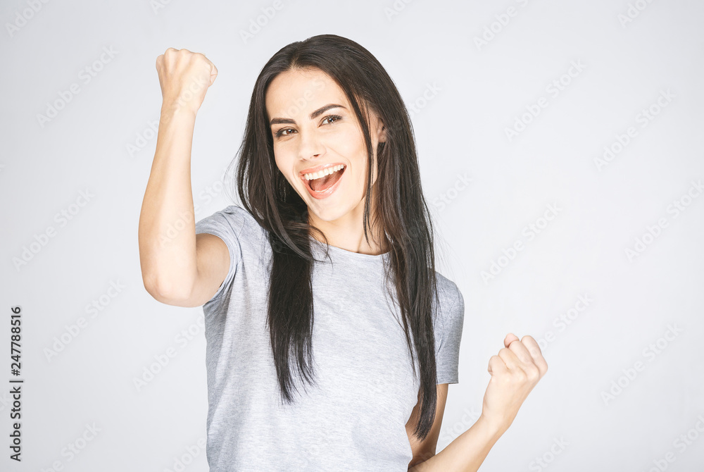 Portrait of happy cute young woman with toothy smile raised hands and celebrate achievement goal. Isolated over white. Portrait of happy cute young woman with toothy smile raised hands and celebrate achievement goal. Isolated over white.
