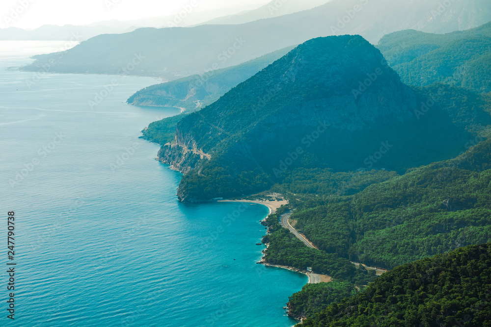 Beautiful sunny amazing aerial view of Turkish marine landscape. Picturesque green foggy mountains. Charming nature background. Antalya city. Horizontal color photography.