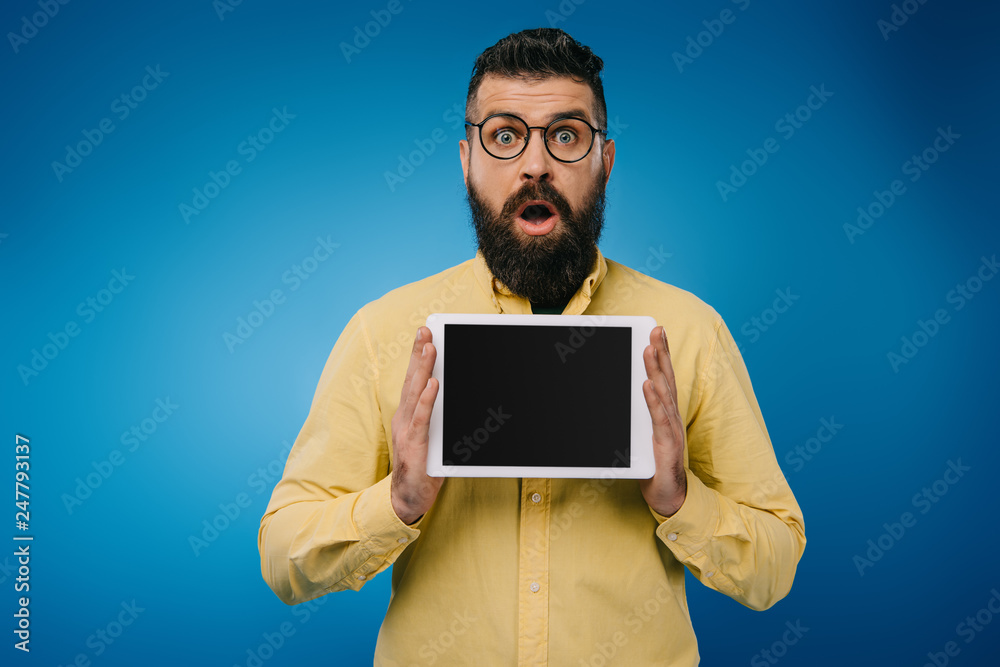 shocked man showing digital tablet with blank screen, isolated on blue shocked man showing digital tablet with blank screen, isolated on blue